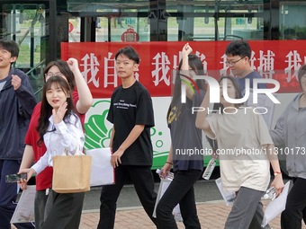 Candidates for the National College entrance examination are waving to teachers delivering exams outside a college entrance examination site...