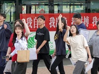 Candidates for the National College entrance examination are waving to teachers delivering exams outside a college entrance examination site...