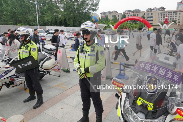 Police officers are on security duty for the national college entrance examination outside a college entrance examination site in Yantai, Ch...