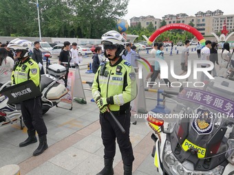 Police officers are on security duty for the national college entrance examination outside a college entrance examination site in Yantai, Ch...