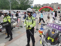 Police officers are on security duty for the national college entrance examination outside a college entrance examination site in Yantai, Ch...