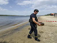 An EOD expert is carrying an old anti-tank mine left from past wars found in the Dnipro River bed during the training of State Emergency Ser...