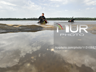 Divers are exploring the Dnipro River bank during the training of State Emergency Service personnel to improve their skills in searching for...