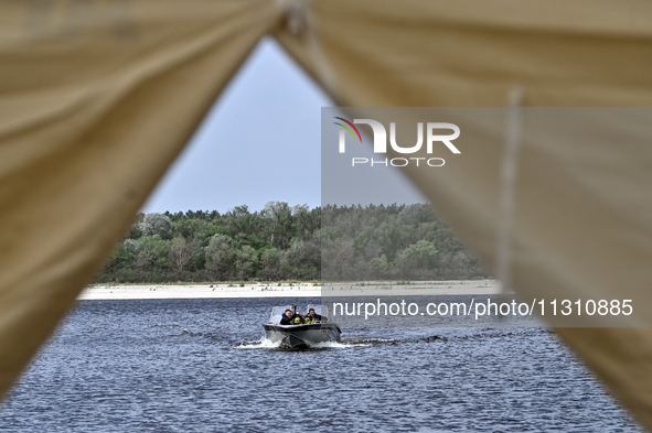 Divers are riding a boat across the Dnipro River during the training of State Emergency Service personnel to improve their skills in searchi...