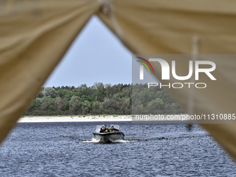 Divers are riding a boat across the Dnipro River during the training of State Emergency Service personnel to improve their skills in searchi...