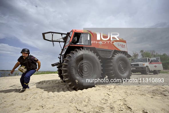 A Bohun-2 snowmobile is towing an SES vehicle that is unable to reach the site of an explosive device due to sandy soil and a flooded floodp...