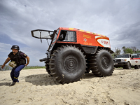 A Bohun-2 snowmobile is towing an SES vehicle that is unable to reach the site of an explosive device due to sandy soil and a flooded floodp...