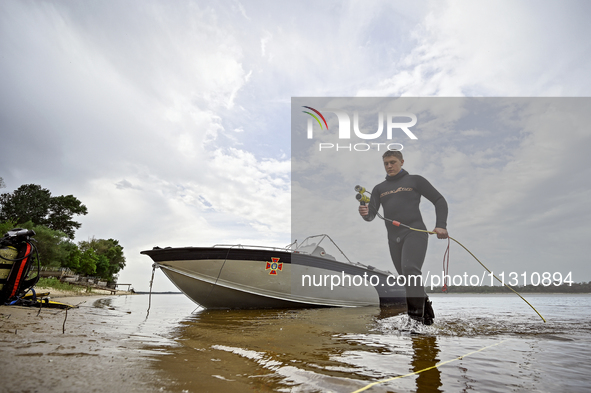 A diver is wading out of the Dnipro River during the training of State Emergency Service personnel to improve their skills in searching for...