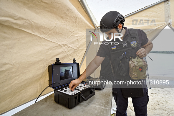 An EOD expert is tuning a piece of equipment during the training of State Emergency Service personnel to improve their skills in searching f...