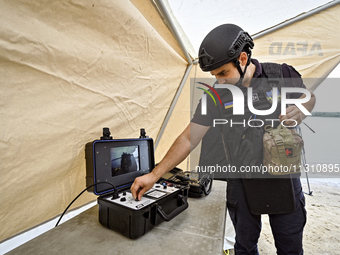 An EOD expert is tuning a piece of equipment during the training of State Emergency Service personnel to improve their skills in searching f...