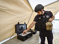 An EOD expert is tuning a piece of equipment during the training of State Emergency Service personnel to improve their skills in searching f...