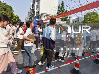 Candidates are lining up to enter a test room to take the National college entrance examination at a college entrance examination site in Fu...