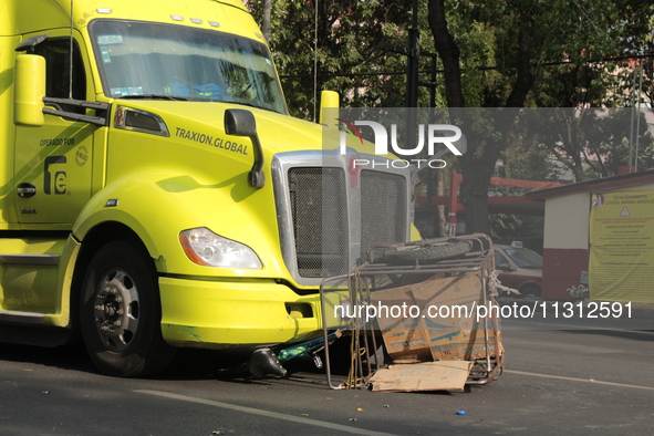 A man of approximately 35 years old is under a cargo truck after losing his life being run over while he is driving his tricycle, on Eje 2 N...