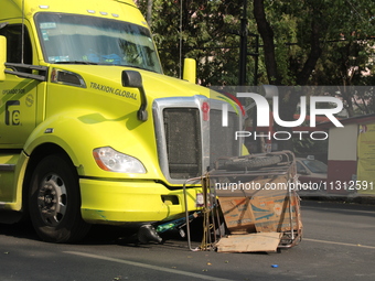 A man of approximately 35 years old is under a cargo truck after losing his life being run over while he is driving his tricycle, on Eje 2 N...