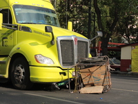 A man of approximately 35 years old is under a cargo truck after losing his life being run over while he is driving his tricycle, on Eje 2 N...