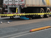 A man of approximately 35 years old is under a cargo truck after losing his life being run over while he is driving his tricycle, on Eje 2 N...