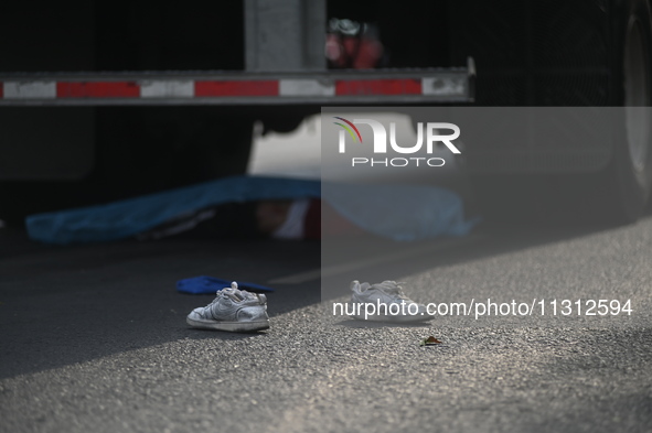 A man of approximately 35 years old is under a cargo truck after losing his life being run over while he is driving his tricycle, on Eje 2 N...