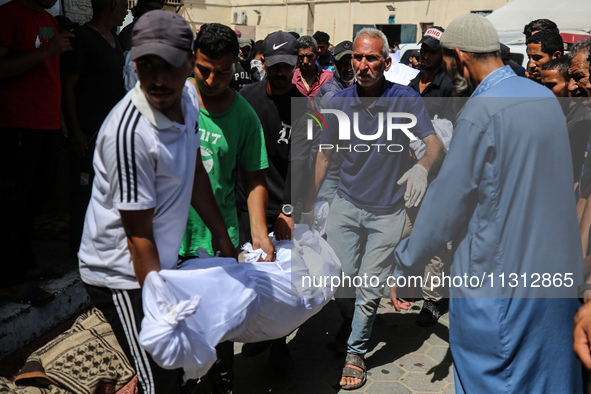 Palestinian mourners are carrying the body of a victim of Israeli bombardment outside a hospital in Deir el-Balah, in the central Gaza Strip...