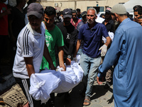 Palestinian mourners are carrying the body of a victim of Israeli bombardment outside a hospital in Deir el-Balah, in the central Gaza Strip...