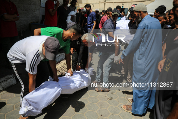 Palestinian mourners are carrying the body of a victim of Israeli bombardment outside a hospital in Deir el-Balah, in the central Gaza Strip...