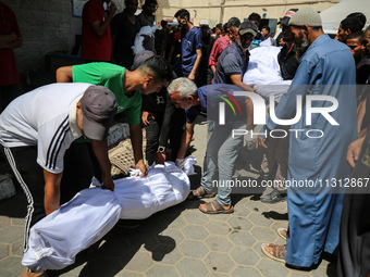 Palestinian mourners are carrying the body of a victim of Israeli bombardment outside a hospital in Deir el-Balah, in the central Gaza Strip...