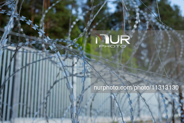 A general view of the area with barbed wire at a sign by the border wall in a forest in Podlasie, Poland, on June 6, 2024. 