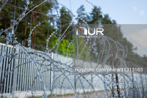 A general view of the area with barbed wire at a sign by the border wall in a forest in Podlasie, Poland, on June 6, 2024. 