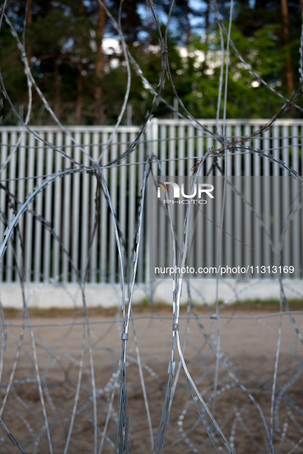 A general view of the area with barbed wire at a sign by the border wall in a forest in Podlasie, Poland, on June 6, 2024. 