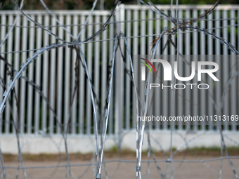 A general view of the area with barbed wire at a sign by the border wall in a forest in Podlasie, Poland, on June 6, 2024. (