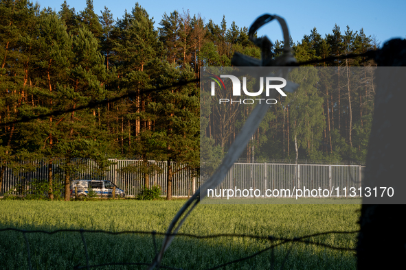 A police car is driving along the border wall in a forest in Podlasie, Poland, on June 6, 2024. 