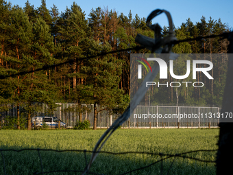 A police car is driving along the border wall in a forest in Podlasie, Poland, on June 6, 2024. (