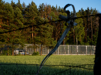 A police car is driving along the border wall in a forest in Podlasie, Poland, on June 6, 2024. (