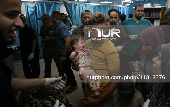 Palestinians are rushing a person into Al-Aqsa Martyrs Hospital in Deir el-Balah in the central Gaza Strip following Israeli bombardment. In...