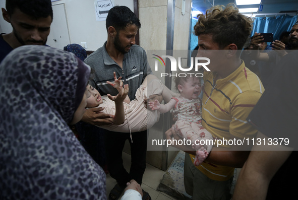 Palestinians are rushing a person into Al-Aqsa Martyrs Hospital in Deir el-Balah in the central Gaza Strip following Israeli bombardment. In...