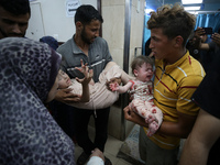 Palestinians are rushing a person into Al-Aqsa Martyrs Hospital in Deir el-Balah in the central Gaza Strip following Israeli bombardment. In...