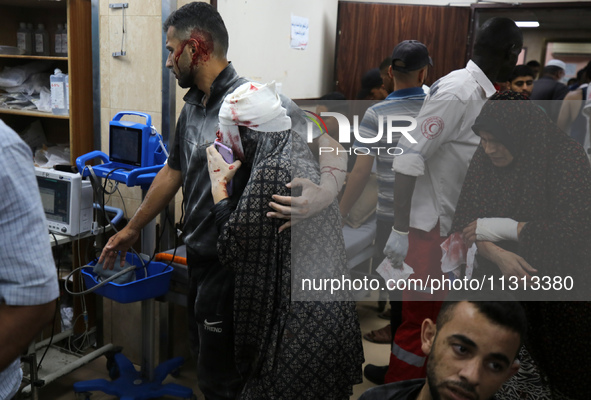 Palestinians are rushing a person into Al-Aqsa Martyrs Hospital in Deir el-Balah in the central Gaza Strip following Israeli bombardment. In...