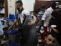 Palestinians are rushing a person into Al-Aqsa Martyrs Hospital in Deir el-Balah in the central Gaza Strip following Israeli bombardment. In...