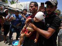 Palestinians are rushing a person into Al-Aqsa Martyrs Hospital in Deir el-Balah in the central Gaza Strip following Israeli bombardment. In...