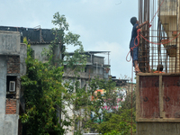 Workers are working using a rope as a safety measure at an under-construction building site in Siliguri, India, on June 8, 2024. (