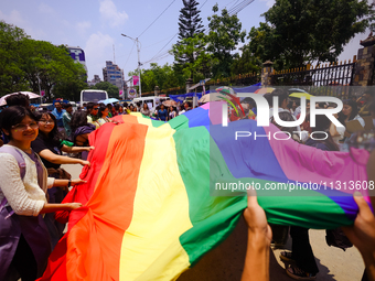 Participants of the 6th Nepal Pride Parade are holding the pride flag as they are marching through the streets of Kathmandu, Nepal, on June...