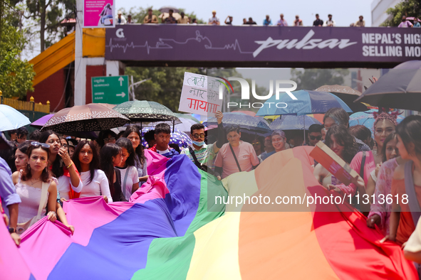 Participants of the 6th Nepal Pride Parade are holding the pride flag as they are marching through the streets of Kathmandu, Nepal, on June...