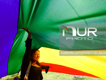 A participant is reacting while sitting under the seven-colored pride flag during the annual Pride Parade in Kathmandu, Nepal, on June 8, 20...