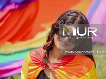 A participant is draped in a pride flag and posing for a photo while attending the annual Pride Parade in Kathmandu, Nepal, on June 8, 2024....