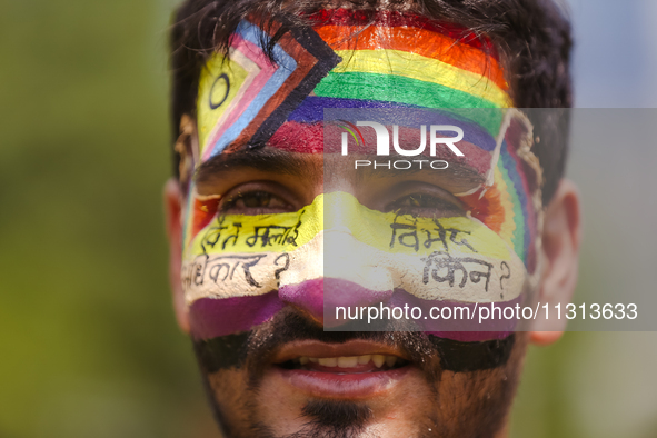 A member of Nepal's sexual minority group, the LGBTQI+, is painting his face with slogans while taking part in the 6th Nepal Pride Parade in...