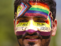 A member of Nepal's sexual minority group, the LGBTQI+, is painting his face with slogans while taking part in the 6th Nepal Pride Parade in...