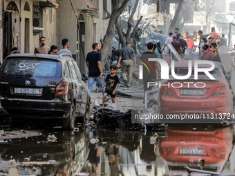 Palestinians are walking on the rubble of destroyed buildings following operations by the Israeli Special Forces in the Nuseirat camp, in th...