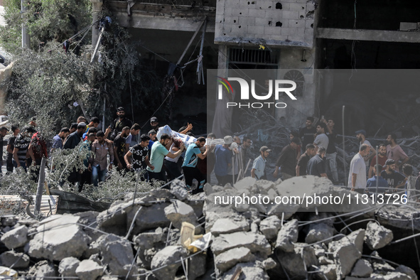 Palestinians are walking on the rubble of destroyed buildings following operations by the Israeli Special Forces in the Nuseirat camp, in th...