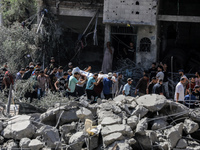 Palestinians are walking on the rubble of destroyed buildings following operations by the Israeli Special Forces in the Nuseirat camp, in th...