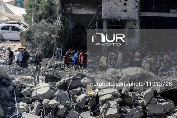 Palestinians are walking on the rubble of destroyed buildings following operations by the Israeli Special Forces in the Nuseirat camp, in th...