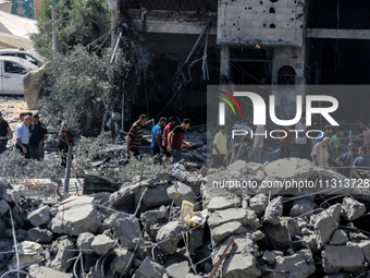 Palestinians are walking on the rubble of destroyed buildings following operations by the Israeli Special Forces in the Nuseirat camp, in th...